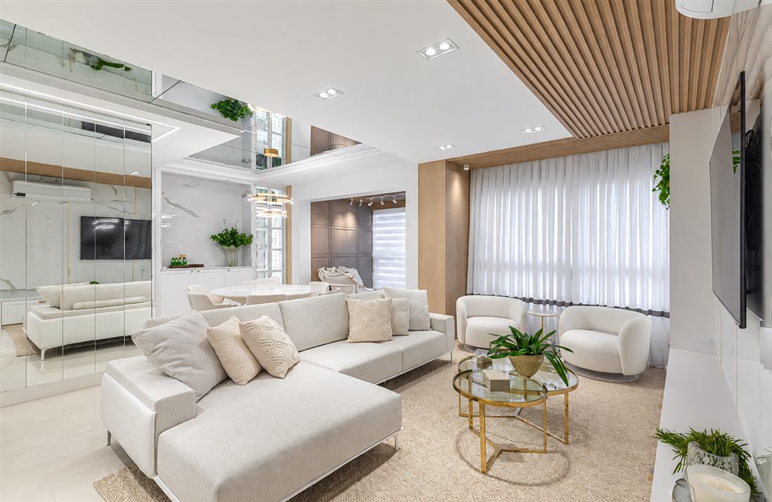 Sala de estar iluminada com cortinas claras e decoração aconchegante